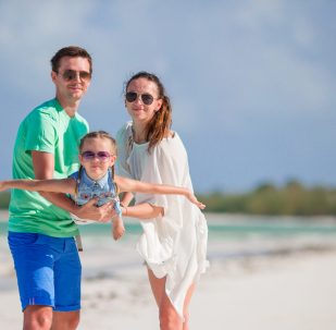 Young family on beach vacation. Family of three enjoy their holidays Happy beautiful family on a beach during summer vacation